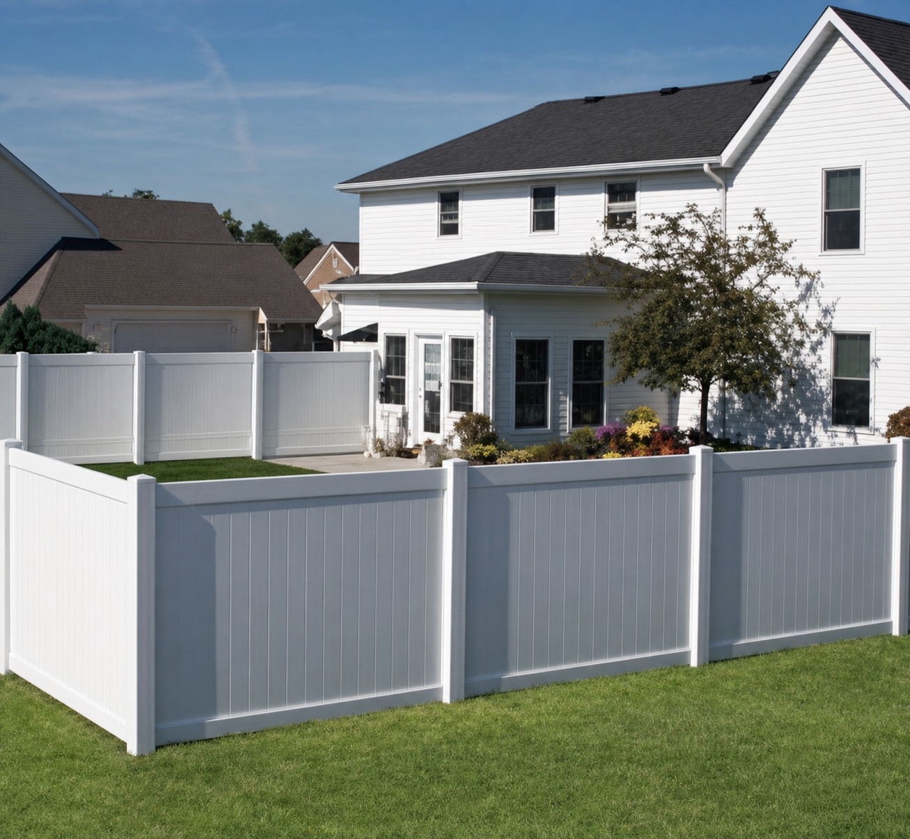 A white vinyl fence surrounding a residential yard